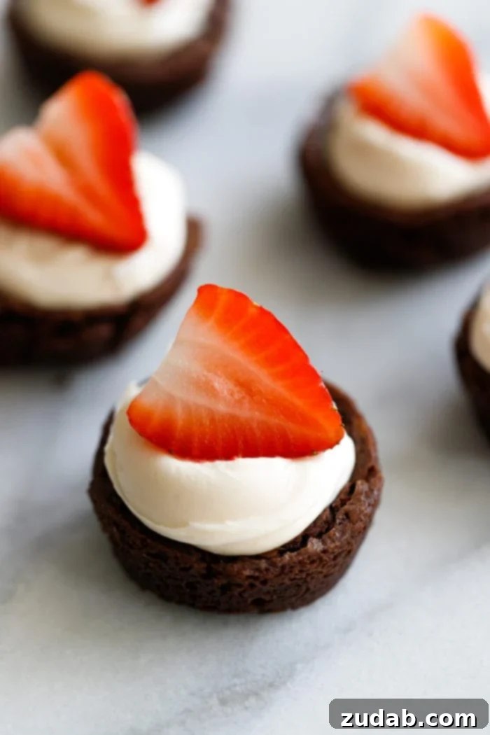 Black Tie Brownie Treats 2 Brownies filled with a cream and topped with a bright red strawberry making elegant strawberry brownie tuxedo cups