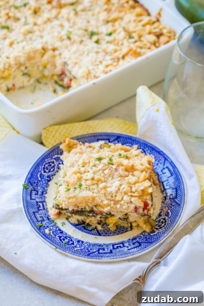 Golden Zucchini Corn Gratin 4 A tantalizing close-up of a single slice of Cheesy Zucchini Corn Casserole on a blue plate, highlighting the perfectly grilled zucchini, sweet corn, diced peppers, and generous melted cheese, all crowned with a golden, crunchy cracker crust.