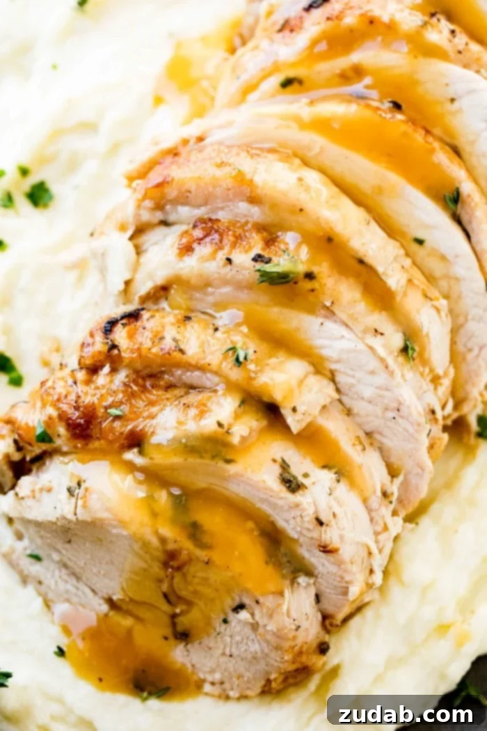 Award-Winning Instant Pot Turkey: The Ultimate Recipe 3 A close-up photo of perfectly sliced Instant Pot turkey breast, generously drizzled with savory gravy and adorned with fresh herbs, resting on a bed of fluffy mashed potatoes.