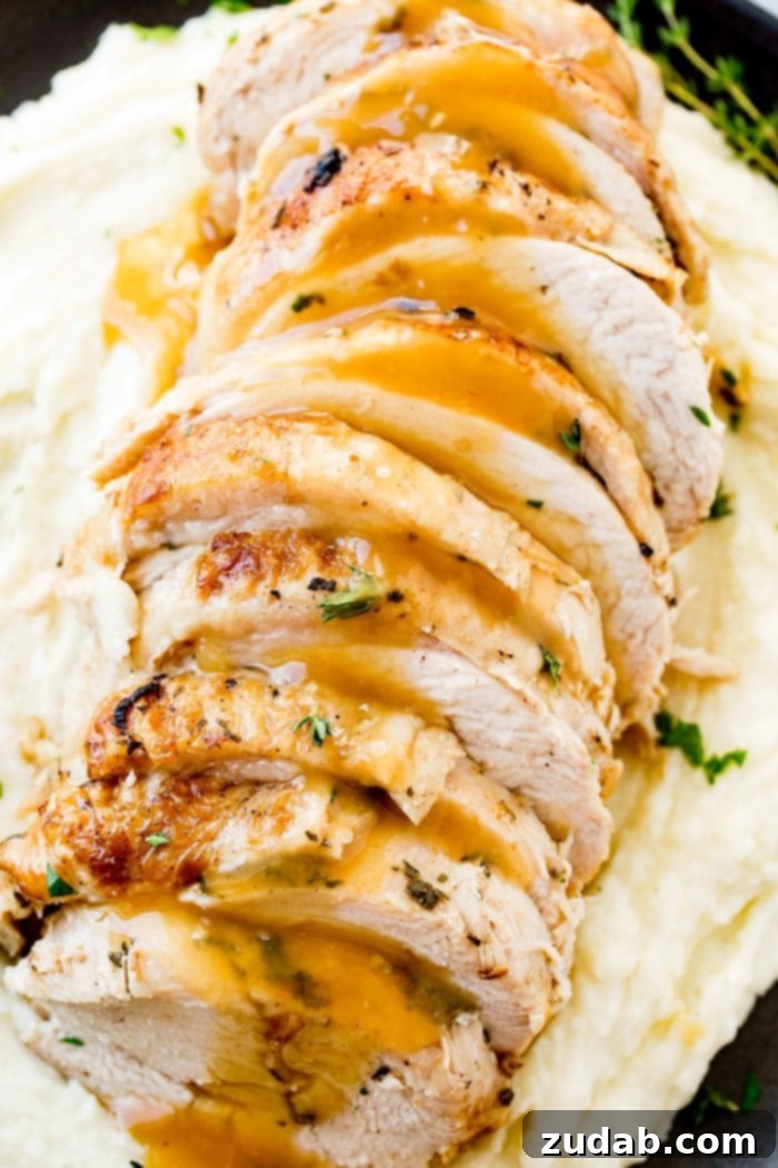 Award-Winning Instant Pot Turkey: The Ultimate Recipe 7 A vibrant photo of perfectly sliced turkey breast, generously drizzled with rich gravy and garnished with fresh herbs, elegantly presented on a bed of fluffy mashed potatoes.