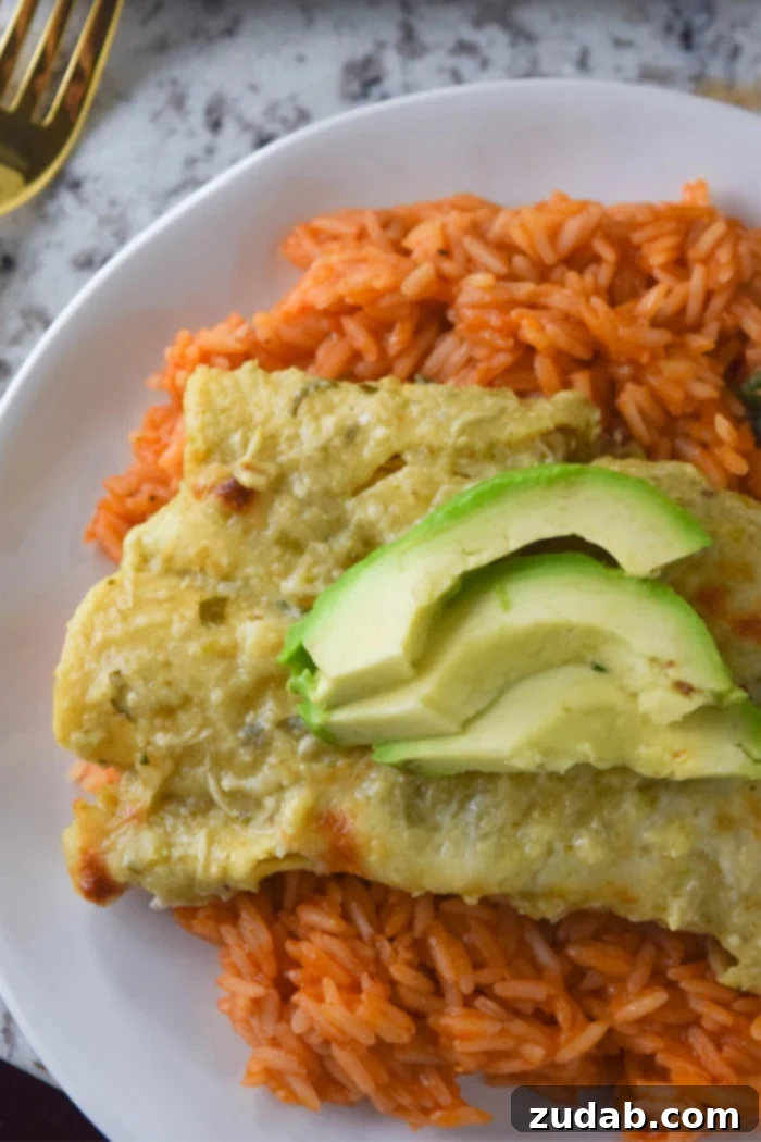 Close-up of baked cheesy chicken enchiladas with roasted tomatillo sauce, ready to serve.