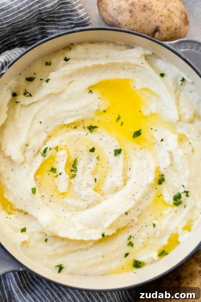 Unlocking Mashed Potato Perfection 2 a grey le creuset pot full of creamy mashed potatoes with butter and parsley