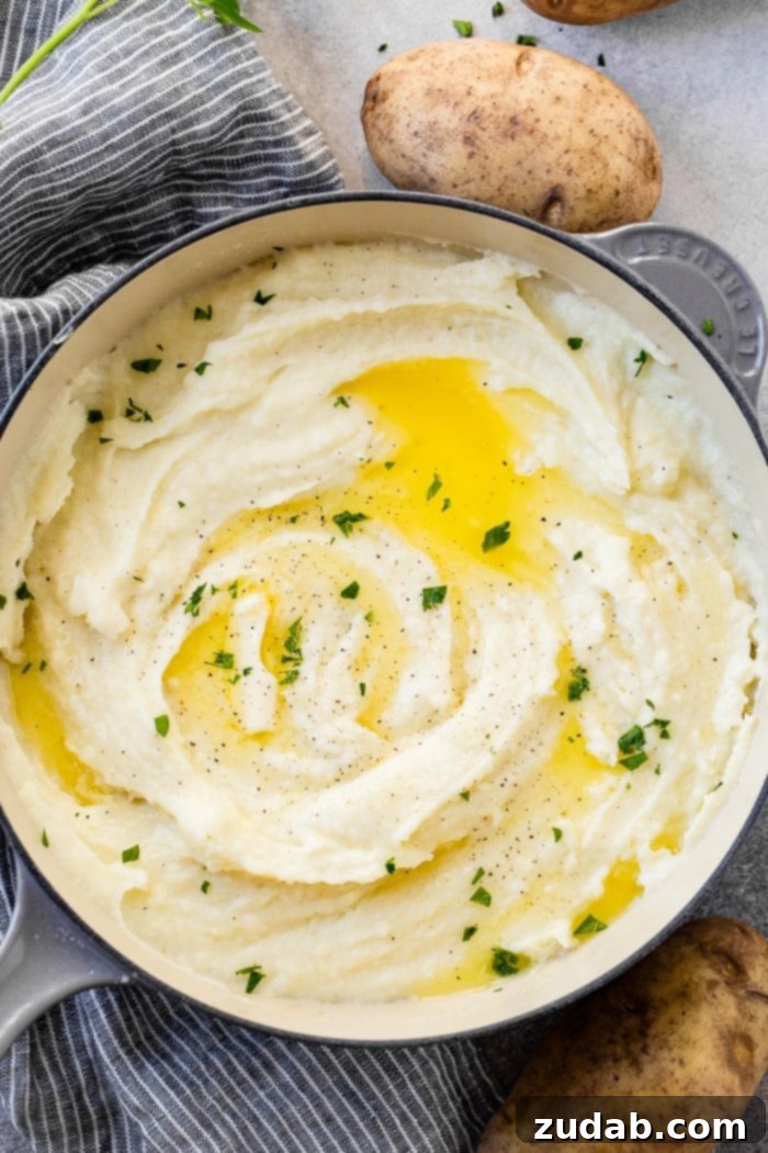 Unlocking Mashed Potato Perfection 3 a grey le creuset pot full of creamy mashed potatoes with butter and parsley