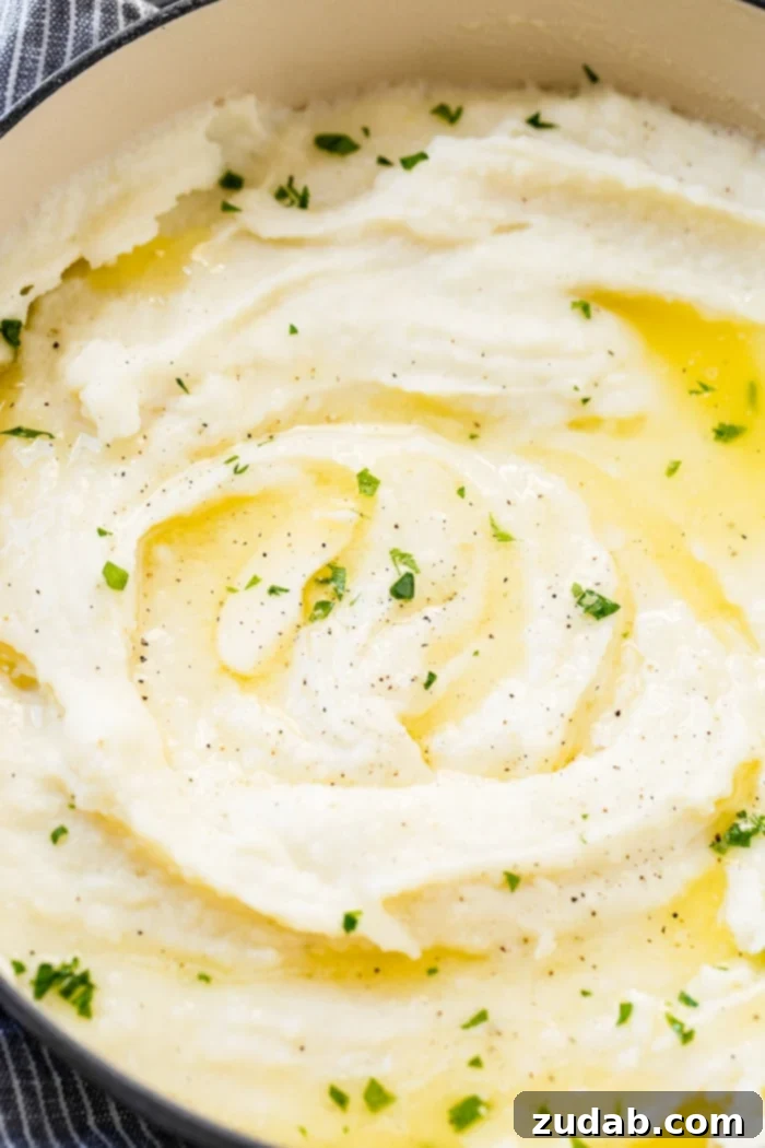 Unlocking Mashed Potato Perfection 4 a grey le creuset pot full of creamy mashed potatoes with butter and parsley