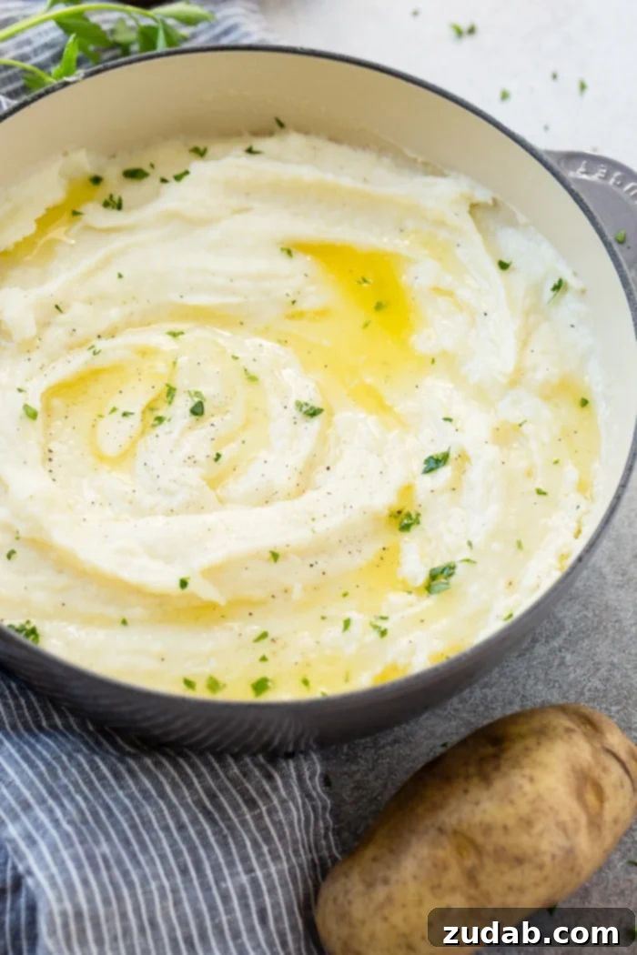 Unlocking Mashed Potato Perfection 5 a grey le creuset pot full of creamy mashed potatoes with butter and parsley