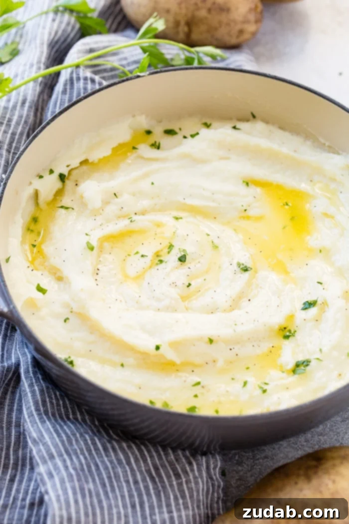 Unlocking Mashed Potato Perfection 7 a grey le creuset pot full of creamy mashed potatoes with butter and parsley
