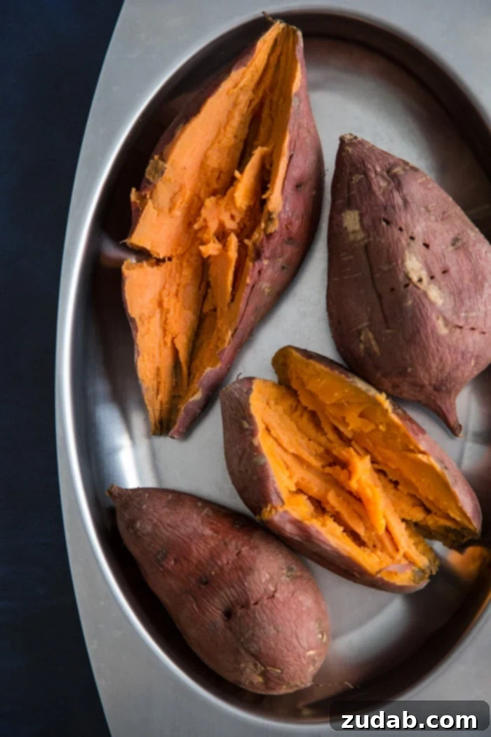 Roasted sweet potato for Sweet Potato Pie Perfectly cooked roasted sweet potatoes with slightly caramelized skins, piled in a bowl, ready to be mashed or pureed for a delectable sweet potato pie filling.