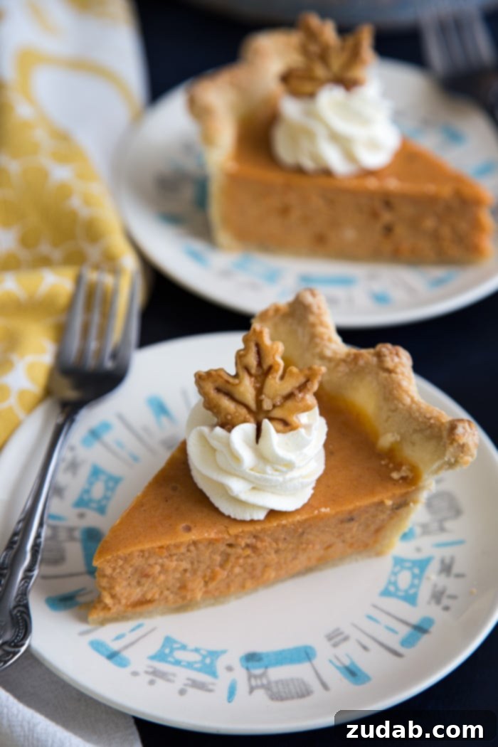 Sweet Potato Pie, made with cream cheese in the filling, a cross between a pie and a cheesecake, guaranteed to be a hit for the holidays. #sweetpotato #sweetpotatopie #sweetpotatocheesecake #holidays Elegant slices of homemade sweet potato pie with creamy cheesecake filling, generously garnished with a swirl of whipped cream and a delicate sprinkle of cinnamon, served on individual dessert plates, capturing the essence of a perfect holiday treat.
