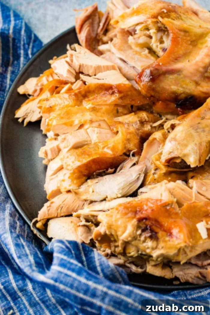 A grey platter displaying succulent, shredded turkey, meticulously cooked using the innovative 'turkey in a bowl' method, promising a delightful texture.