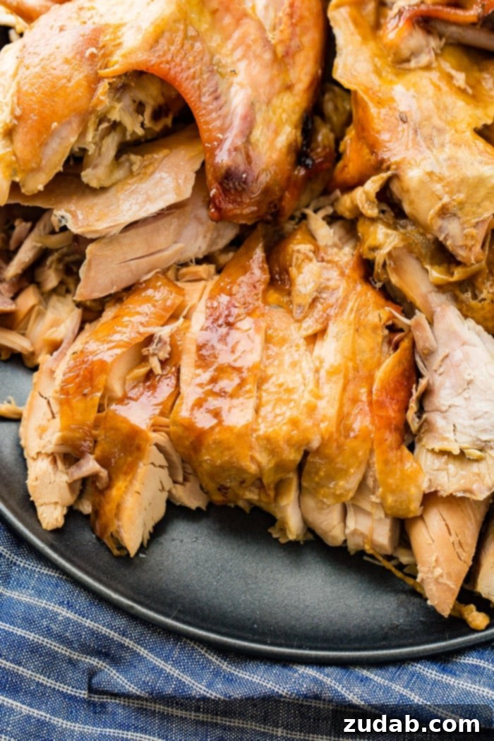 A grey platter beautifully arranged with juicy, shredded turkey, a testament to the perfect cooking achieved through the 'turkey in a bowl' method.