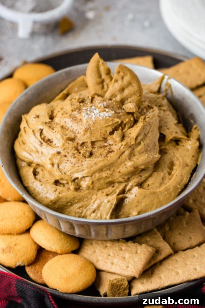 Creamy Gingerbread Delight 3 a silver bowl full of fluffy gingerbread cookie dip or molasses cookie dip with graham crackers and nilla wafers