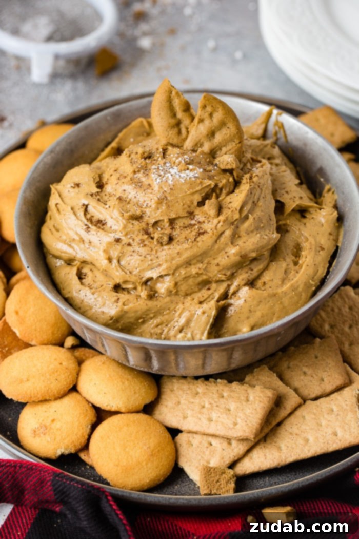 Creamy Gingerbread Delight 7 a silver bowl full of fluffy gingerbread cookie dip or molasses cookie dip with graham crackers and nilla wafers
