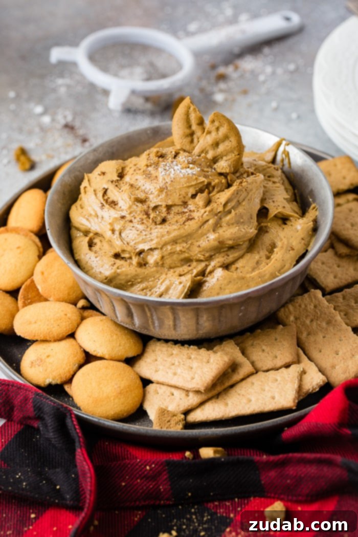 Creamy Gingerbread Delight 5 a silver bowl full of fluffy gingerbread cookie dip or molasses cookie dip with graham crackers and nilla wafers