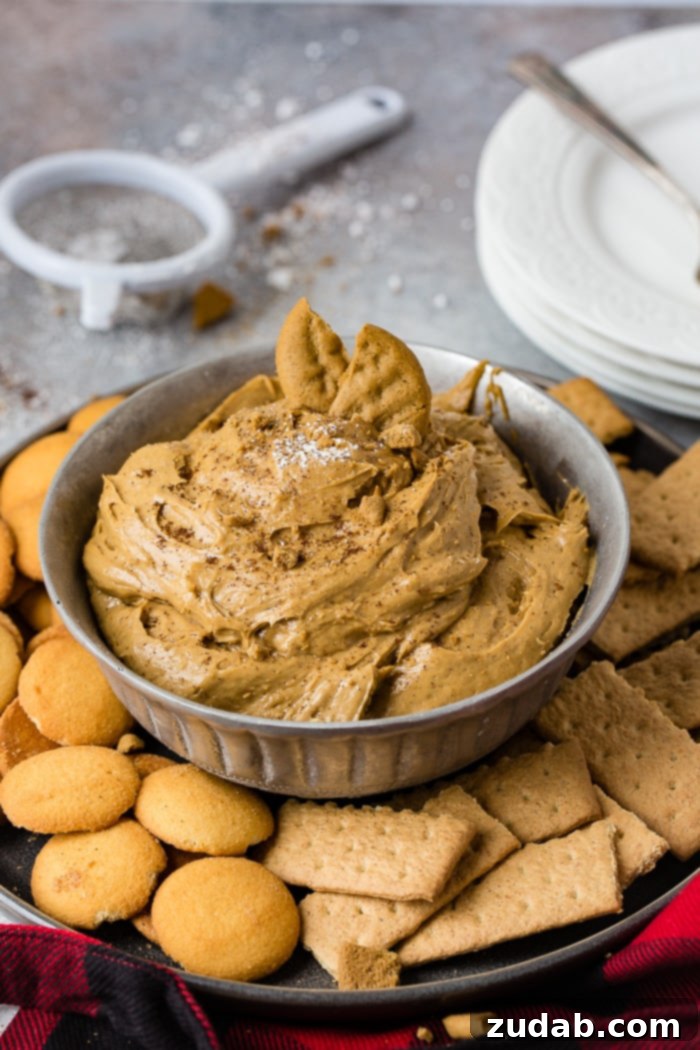 Creamy Gingerbread Delight 9 a silver bowl full of fluffy gingerbread cookie dip or molasses cookie dip with graham crackers and nilla wafers