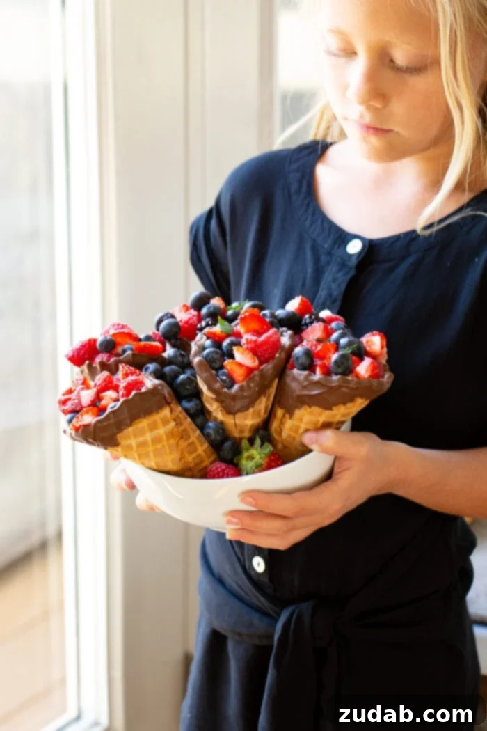 Waffle Cone Fruit Yogurt Parfaits 4 My daughter holding a bowl of waffle cones filled with berries.