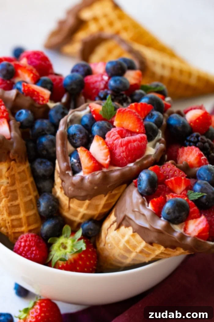 Waffle Cone Fruit Yogurt Parfaits 5 A bowl filled with fresh berries and waffle cones filled with yogurt and berries.