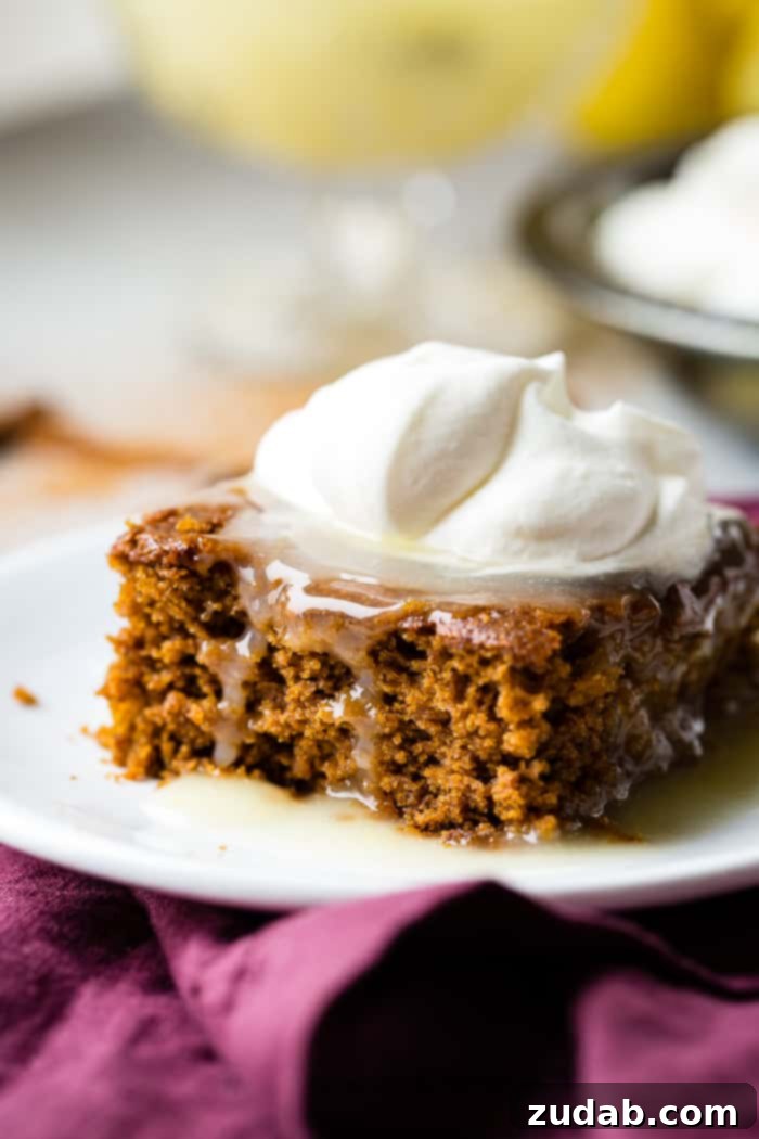 Spiced Ginger Cake with Zesty Lemon Glaze 5 A close-up shot of a warm slice of gingerbread cake, generously coated with bright lemon sauce and topped with fluffy whipped cream, emphasizing its festive appeal.