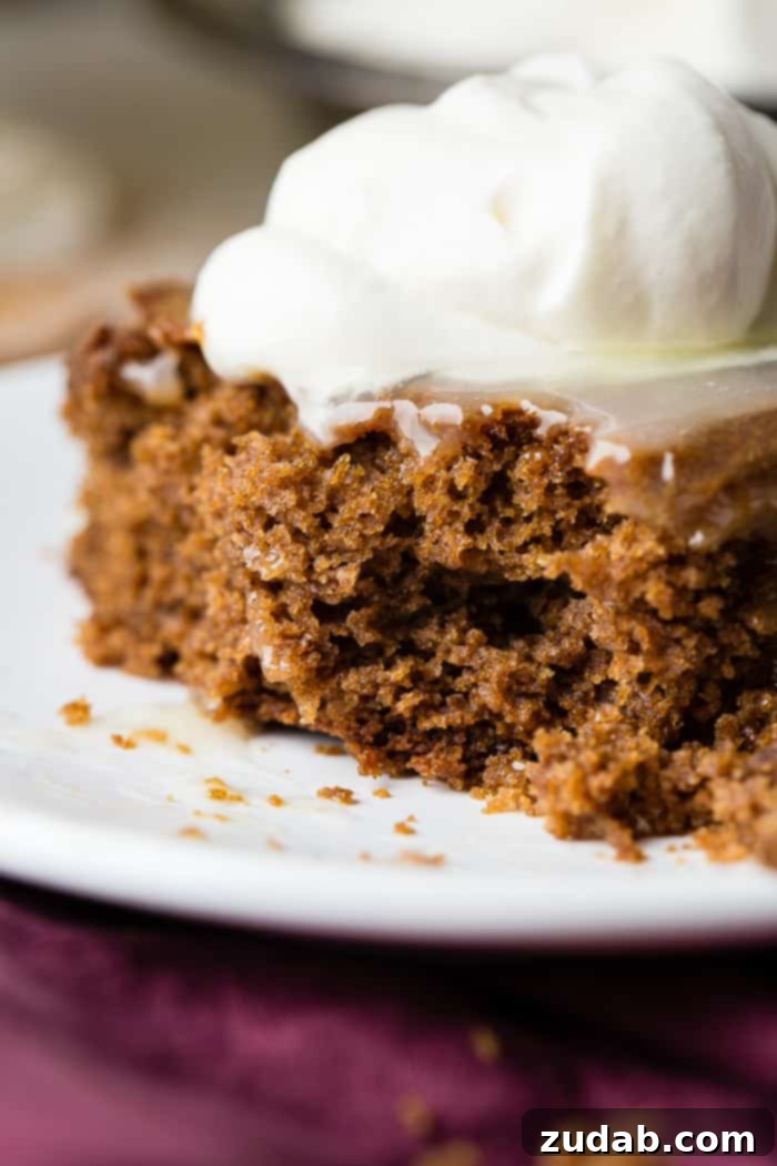 Spiced Ginger Cake with Zesty Lemon Glaze 7 A beautifully presented slice of gingerbread cake, with its inviting warm hue, luscious lemon sauce, and a generous dollop of whipped cream, creating a perfect festive dessert.