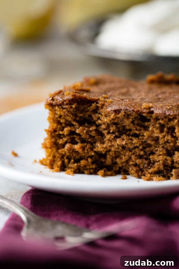 Spiced Ginger Cake with Zesty Lemon Glaze 8 An artfully composed shot of a warm gingerbread cake slice, rich with lemon sauce and whipped cream, inviting viewers to savor its festive comfort.
