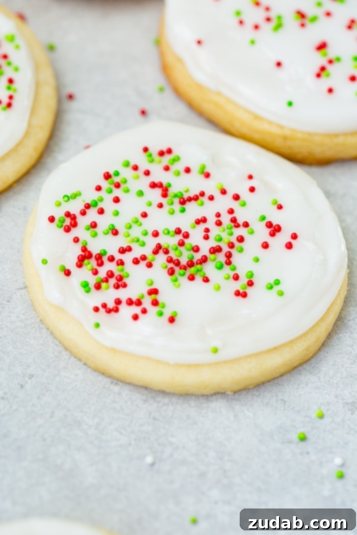 Festive Peppermint White Chocolate Sugar Cookies 4 A photo of a sugar cookie frosted with white royal icing with red and green sprinkles