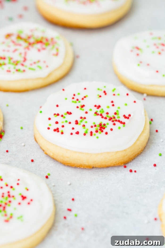 Festive Peppermint White Chocolate Sugar Cookies 5 A photo of several round sugar cookies with white royal icing and red and green sprinkles