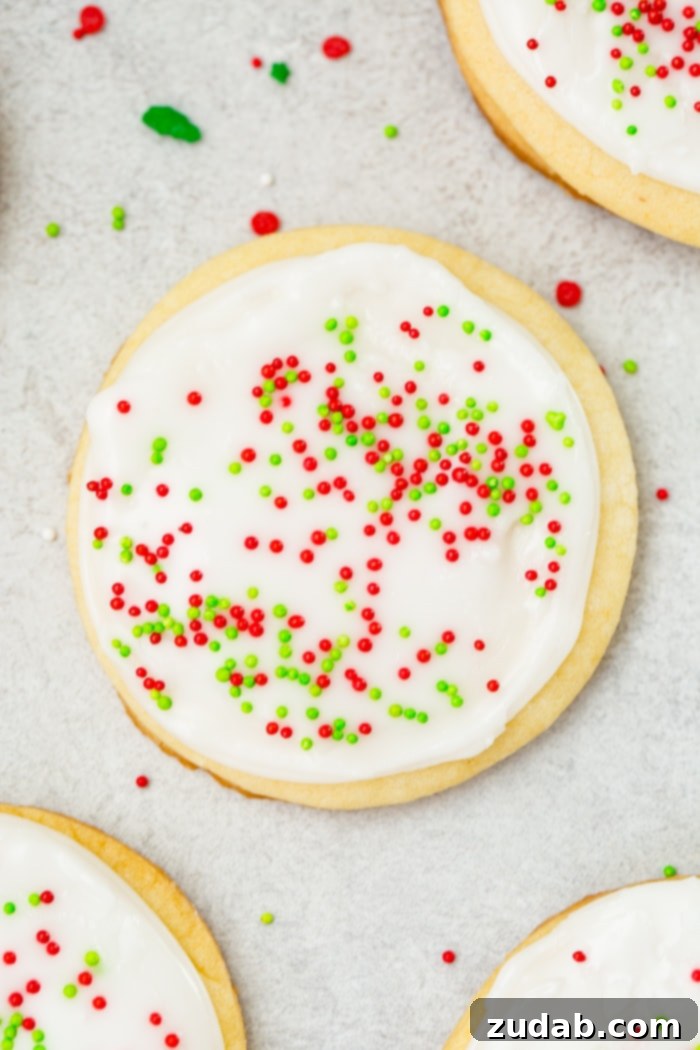 Festive Peppermint White Chocolate Sugar Cookies 8 A photo of a sugar cookie frosted with white royal icing with red and green sprinkles