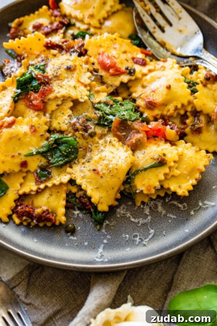 Crispy Pancetta Ravioli: Sun-Kissed Tomato & Spinach Delight 7 A close-up of a skillet full of cooked Easy Crispy Pancetta Ravioli, mixed with sun-dried tomatoes, spinach, and garlic, steaming hot and ready to eat.