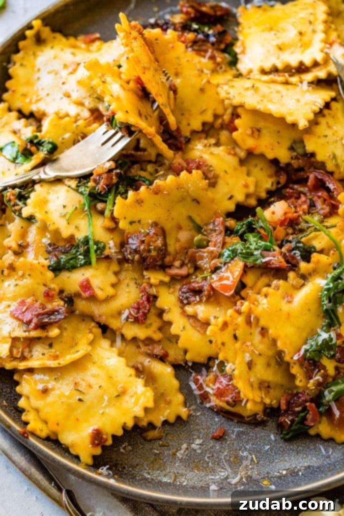 Crispy Pancetta Ravioli: Sun-Kissed Tomato & Spinach Delight 8 A vibrant, close-up overhead shot of Easy Crispy Pancetta Ravioli in a skillet with sun-dried tomatoes, spinach, and fresh grape tomatoes.