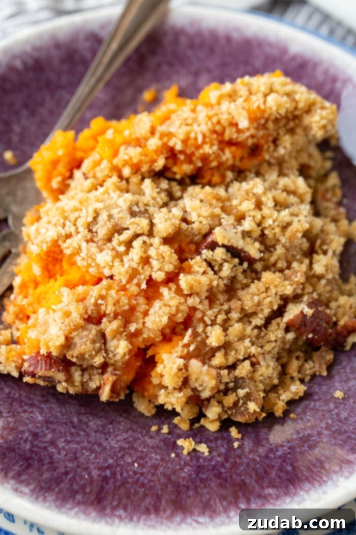 This Sweet Potato Souffle Outshines Ruths Chris 4 A large serving of golden brown sweet potato souffle with a crunchy, baked topping, ready to be enjoyed.