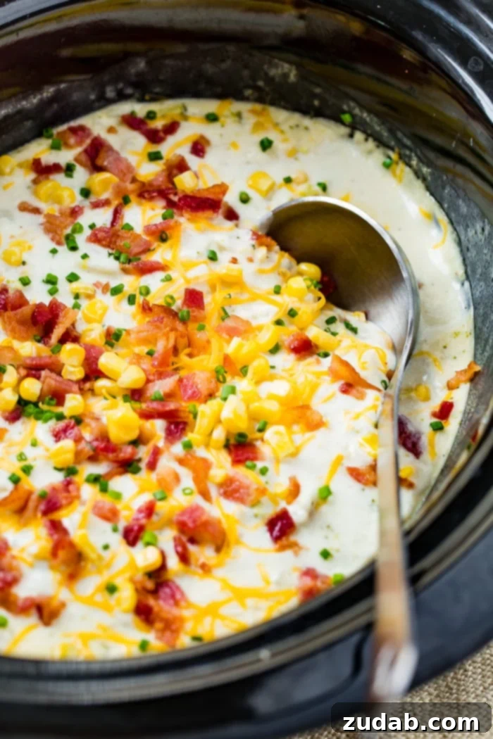 Creamy Slow Cooker Potato, Broccoli & Corn Chowder with Crispy Bacon 2 A slow cooker filled with creamy potato broccoli corn chowder, garnished with bacon and a silver ladle resting on the side.