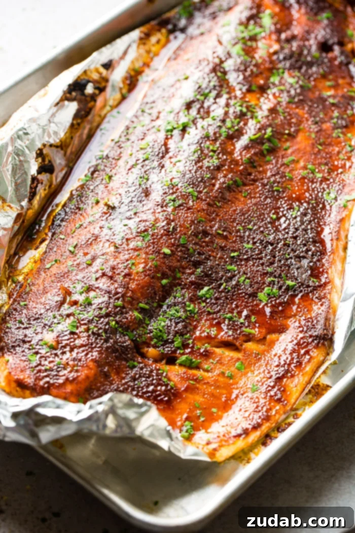 maple glazed salmon in foil with a fork taking a bite