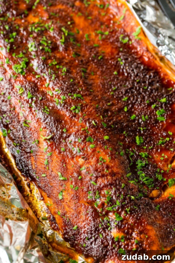 maple syrup salmon in foil with a fork taking a bite