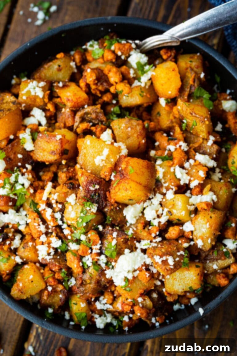 Simple Chorizo Potato Skillet 4 A beautifully plated dish of golden chorizo and potatoes, generously mixed with crumbled cotija cheese and a sprinkle of fresh cilantro, ready to be enjoyed.