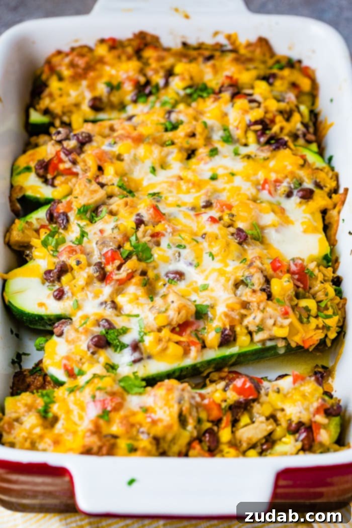 Guilt-Free Cheesy Mexican Zucchini Boats 4 A third image showing the cheesy healthy Mexican zucchini boats baked to perfection in a casserole dish. The cheese is melted and slightly browned, indicating a delicious, comforting meal. Fresh herbs are scattered over the top.
