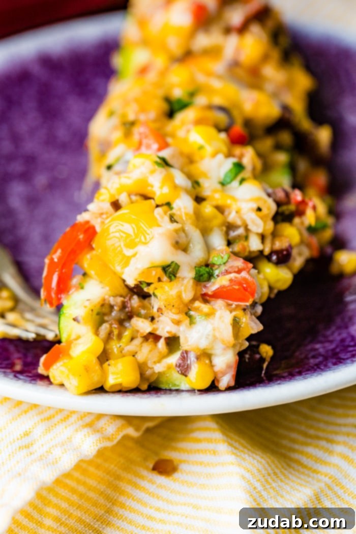 Guilt-Free Cheesy Mexican Zucchini Boats 6 A close-up shot of a single cheesy healthy Mexican zucchini boat, showing the rich, vibrant filling and melted cheese. This inviting image emphasizes the deliciousness and healthiness of the dish.