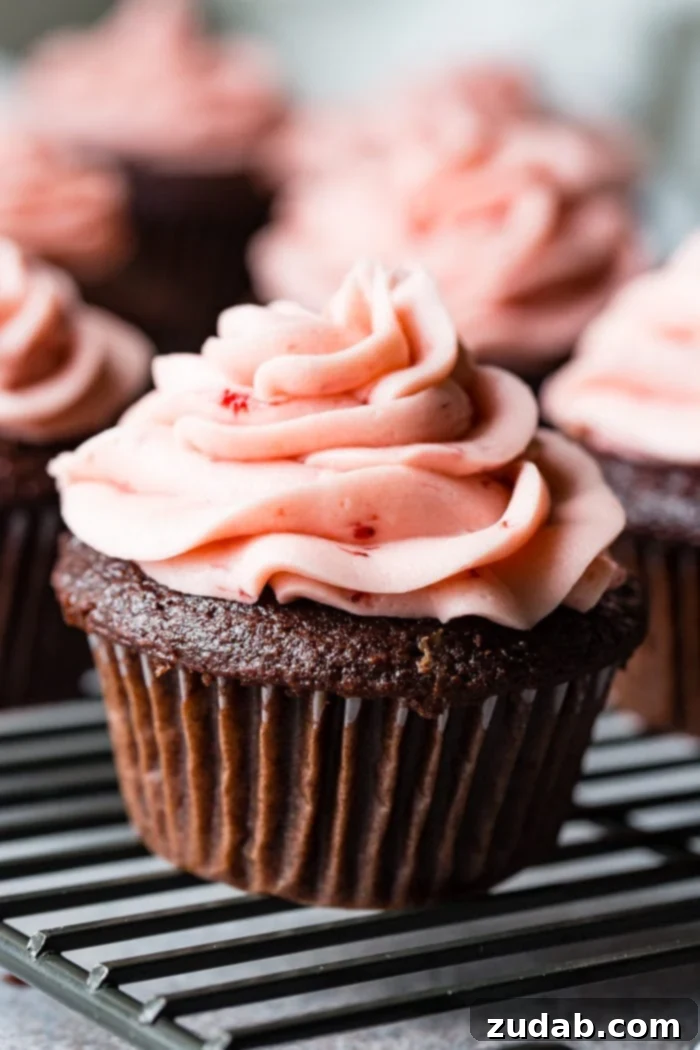 Nutella Lava Strawberry Chocolate Cupcakes 3 a close up of a nutella stuffed chocolate cupcake with strawberry buttercream frosting