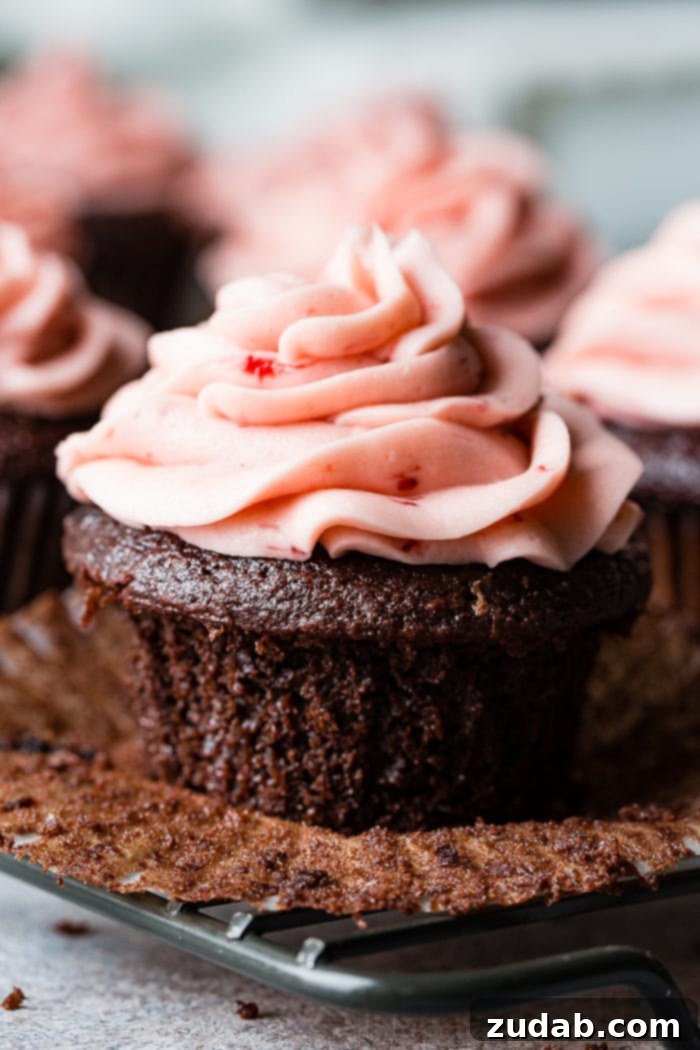 Nutella Lava Strawberry Chocolate Cupcakes 5 a close up of a nutella stuffed chocolate cupcake with strawberry buttercream frosting
