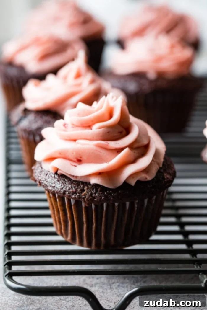 Nutella Lava Strawberry Chocolate Cupcakes 8 a close up of a nutella stuffed chocolate cupcake with strawberry buttercream frosting