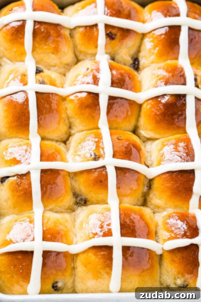Pillowy Soft Hot Cross Buns 5 A photo looking down on a pan of hot cross buns with white frosting crosses on them.