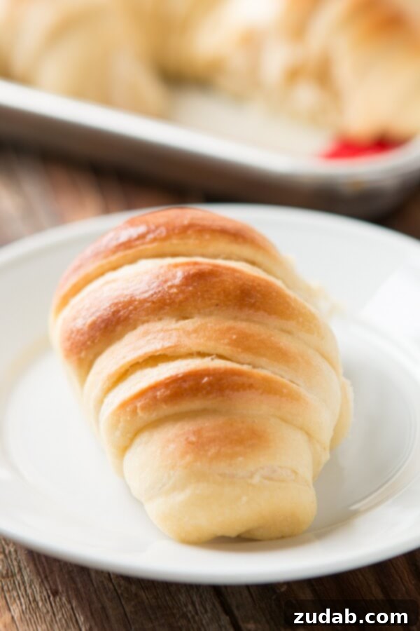 Freshly baked potato rolls cooling on a wire rack, steam gently rising, highlighting their tender texture.