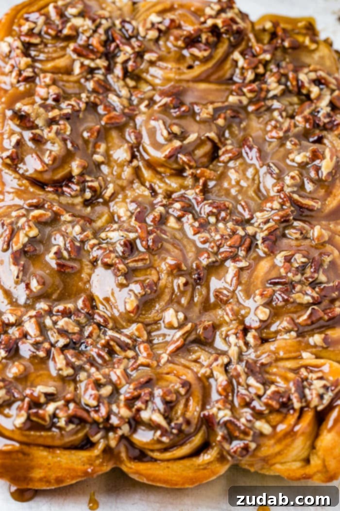 Irresistible Pecan Sticky Buns 4 A photo of a dozen sticky buns coated in caramel glaze and chopped pecans.