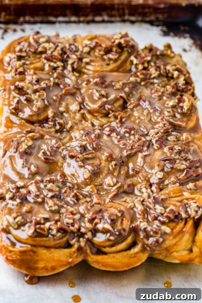 Irresistible Pecan Sticky Buns 6 A photo of a dozen sticky buns coated in caramel glaze and chopped pecans.