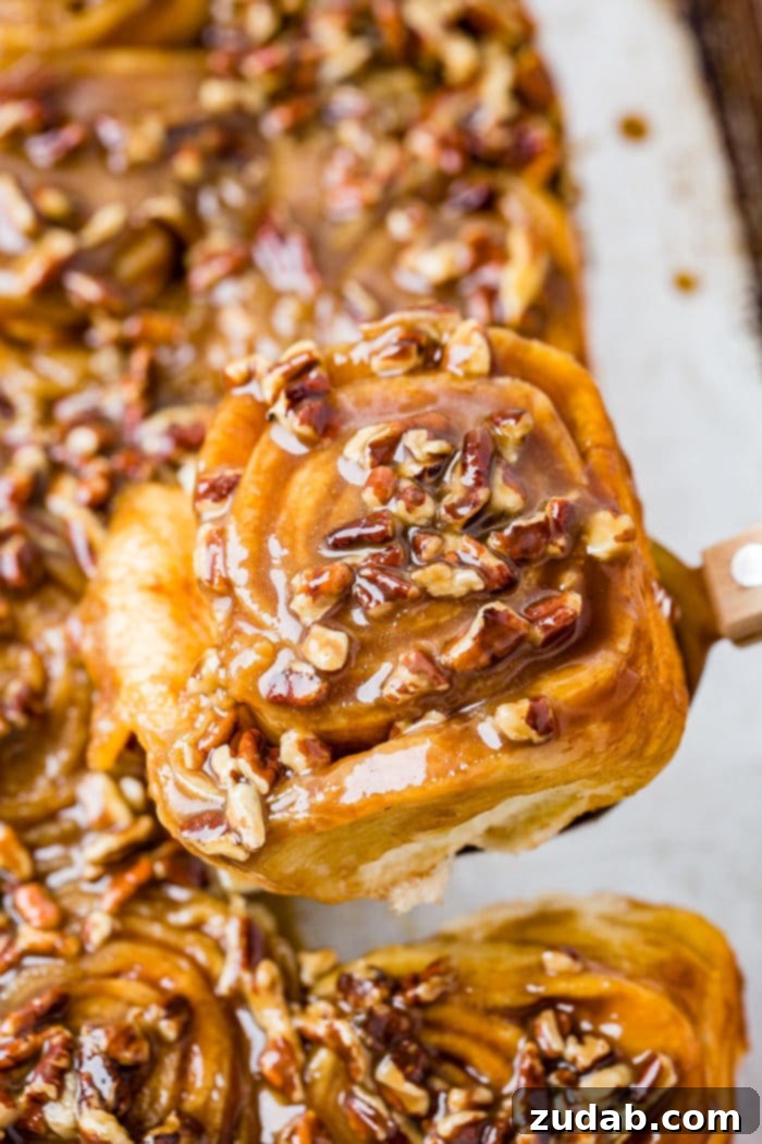 Irresistible Pecan Sticky Buns 7 A photo of a sticky bun taking from above covered in a caramel glaze and chopped pecans.