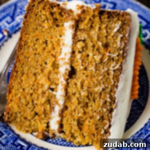 My Signature Spiced Carrot Cake 9 A photo of a slice of two layer carrot cake laying on its side on a blue and white plate.