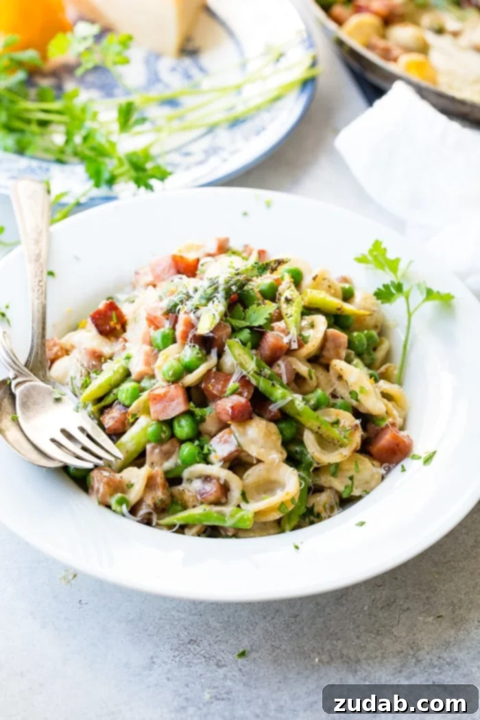Creamy lemon pasta with caramelized ham, vibrant asparagus, and tender peas.