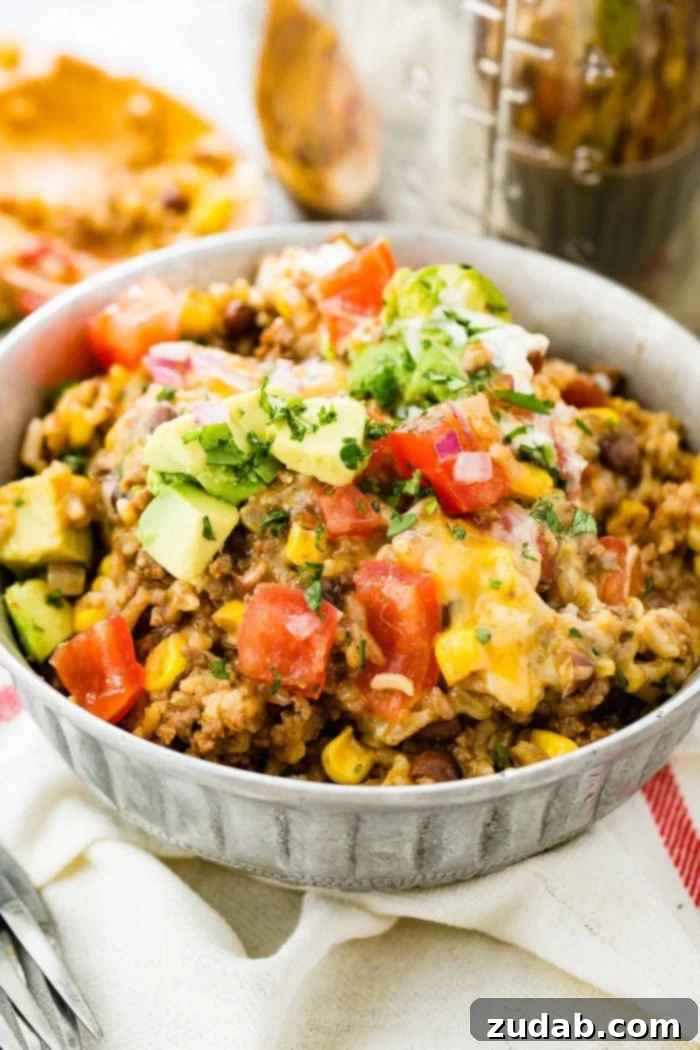 Instant Pot Ground Beef Burrito Bowls in Minutes 2 A vibrant Instant Pot Ground Beef Burrito Bowl, generously topped with freshly chopped tomatoes, creamy avocado chunks, and aromatic fresh cilantro, ready to be enjoyed.