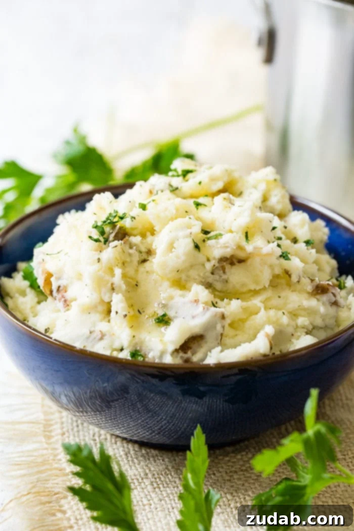 Crispy Garlic Smashed Potatoes 2 A vibrant blue serving bowl brimming with golden smashed potatoes, speckled with fresh green chopped parsley, ready to be enjoyed.