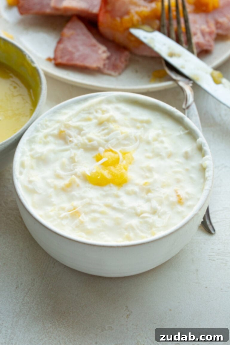 Simple Sauces That Make Ham Shine 8 A charming small bowl brimming with bright Pina Colada ham dipping sauce, set against a backdrop of carefully arranged ham slices.
