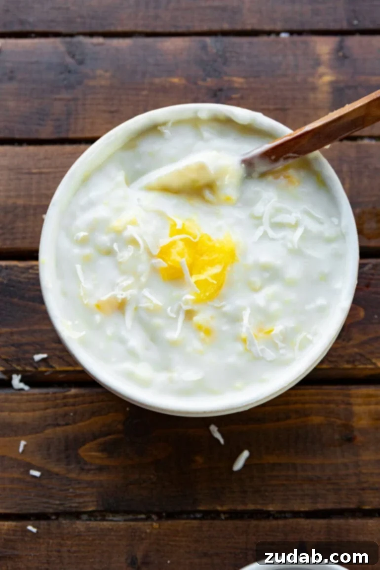 Simple Sauces That Make Ham Shine 9 A close-up, appealing shot of a small bowl overflowing with creamy pina colada dipping sauce, showcasing its rich texture and tropical appeal.