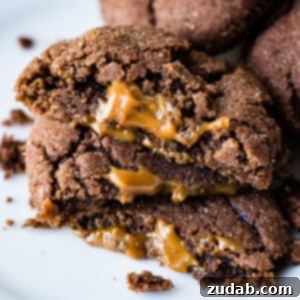 Dulce De Leche-Filled Mexican Chocolate Delights 6 A photo of three dulce de leche stuffed chocolate cookies halved and stacked on top of each other with dulce de leche oozing out of the middle..